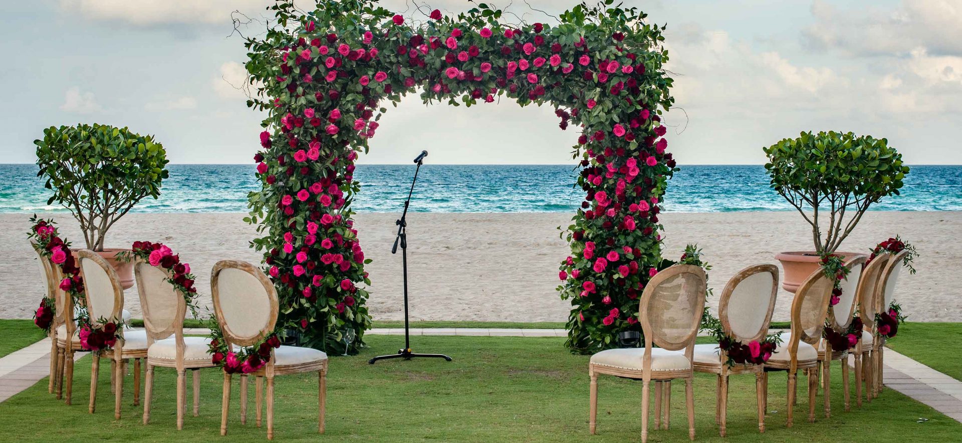 Flower arch and chairs set up for a beachfront Acqualina wedding