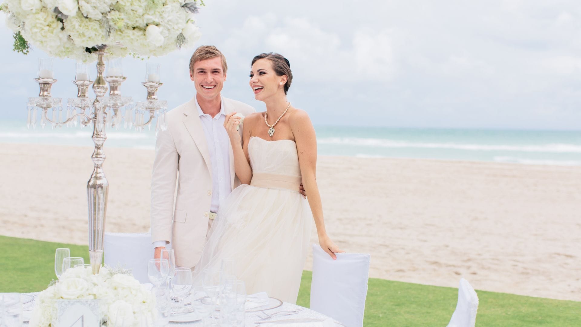 Couple celebrating a beachfront wedding ceremony at Acqualina Resort