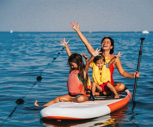 family paddleboarding together on the ocean