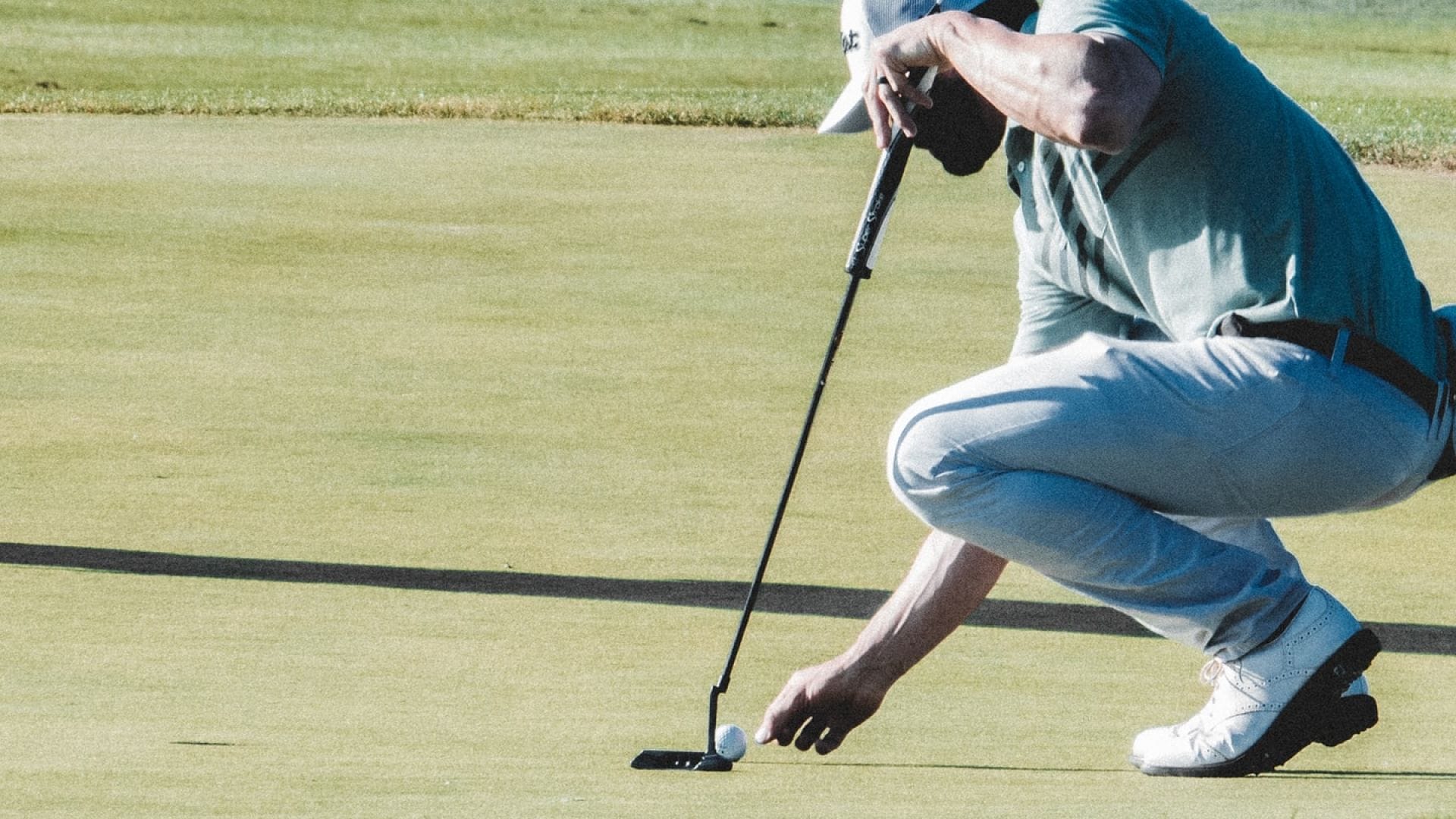 golfer lining up a putt on the green