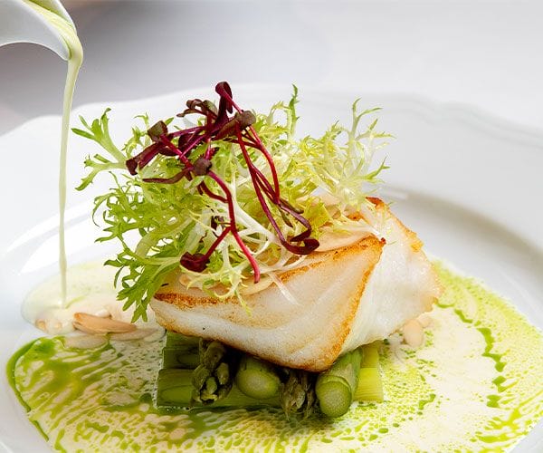 gourmet white fish with asparagus and fresh greens